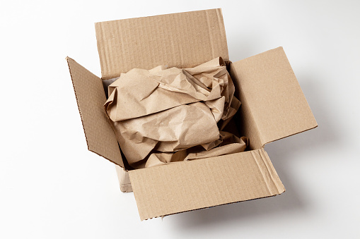 Open cardboard box with wrapping paper inside. Gentle dispatch of goods. Cargo insurance