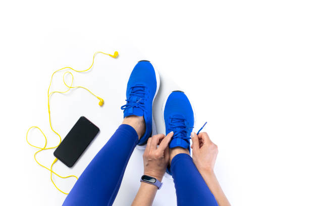 Woman tying shoelace before workout Young woman tying shoelace before workout, getting ready for jogging in bounds stock pictures, royalty-free photos & images