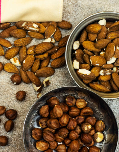 istock metal bowls of nuts, almond and hazelnut 1323188540