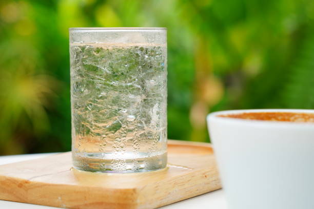Pink Gin and tonic with ice on a water glass..