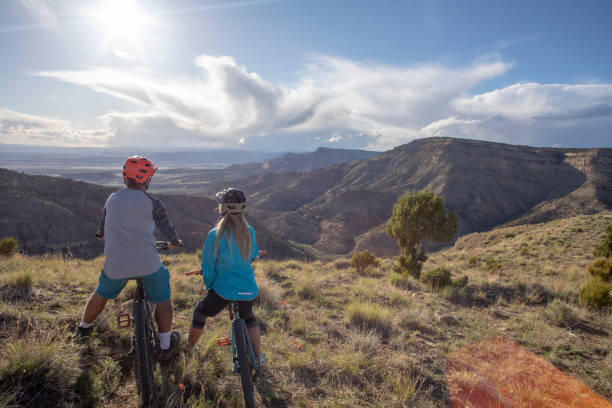 istock Mountain bikers relax at viewpoint on mountain ridge 1323199911