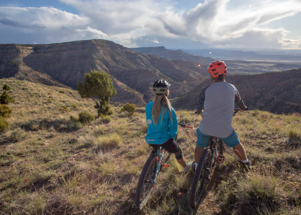 istock Mountain bikers relax at viewpoint on mountain ridge 1323200513