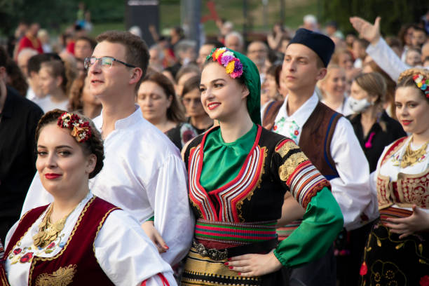 jovens dançarinos folclóricos vestindo trajes tradicionais caminham pelas ruas de belgrado em procissão - serbian culture - fotografias e filmes do acervo