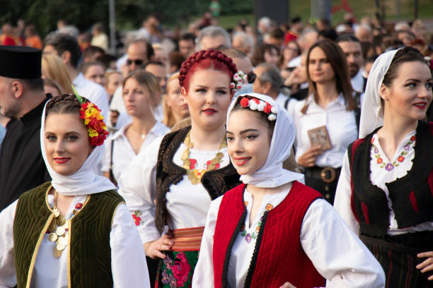 молодые женщины народные танцоры в традиционных костюмах ходить белград улицы в процессии - serbian culture стоковые фото и изображения