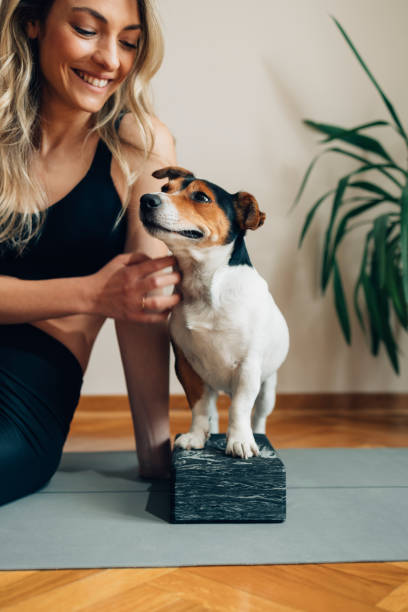 istock Happy Young Woman Sitting on the Exercise Mat with Her Dog 1323202053