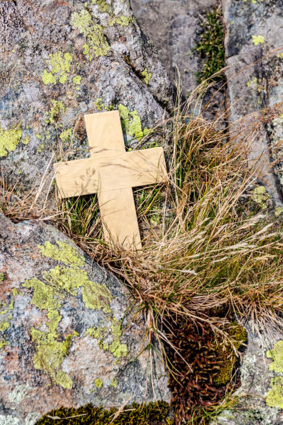istock Wooden Cross Amongst Rocks and Grass 1323205685