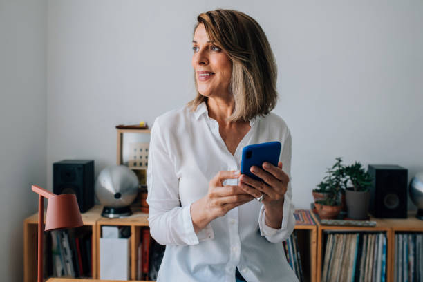 istock Portrait of a Smiling Mature Woman Using her Mobile Phone at Work 1323206605