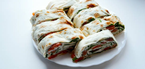 istock Salmon salad sandwich on a white plate. Roll lavash sandwich with red fish and lettuce. Thin Armenian lavash or lavash. Snack. 1323207896