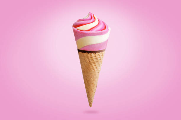 istock Pink and yellow ice cream in waffles cone on a pink background 1323209145