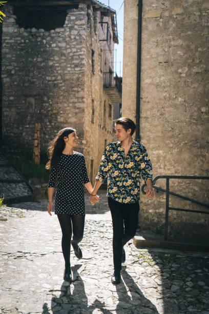 istock Young couple walk down cobblestone streets of Lugano 1323209257