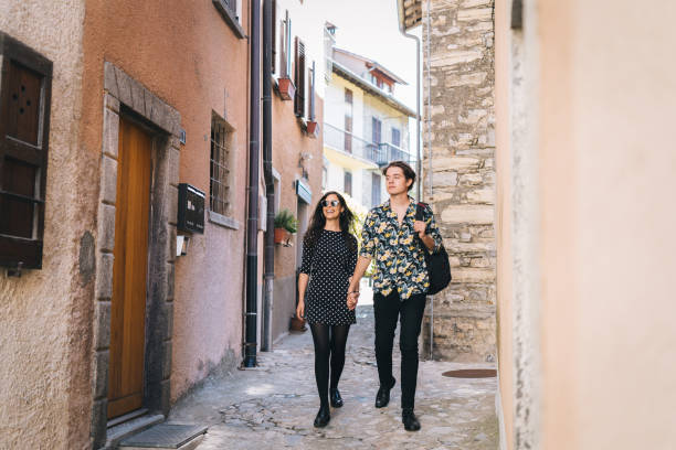 istock Young couple walk down cobblestone streets of Lugano 1323209351