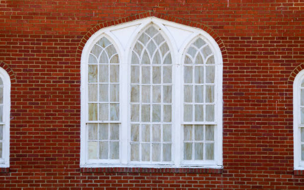 istock bright red brick church wall facade with white stained glass arched windows 1323210280