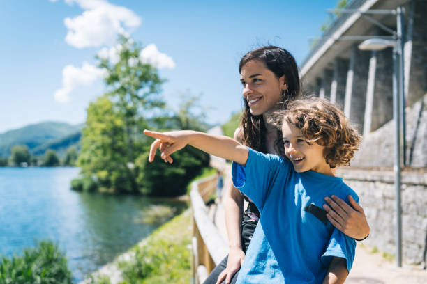 istock Young woman balances with son on wooden fence 1323210320