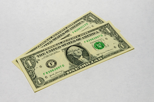 Two US dollars on a white background.