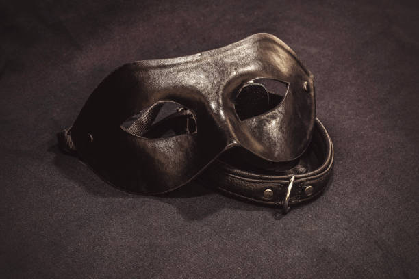 istock Top view of collar and black mask on black textile background 1323215744
