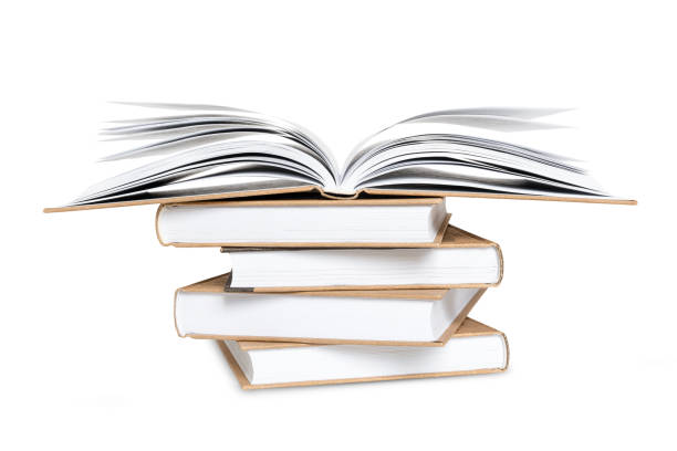 istock Open book lying on high stack of books isolated on white background 1323217834