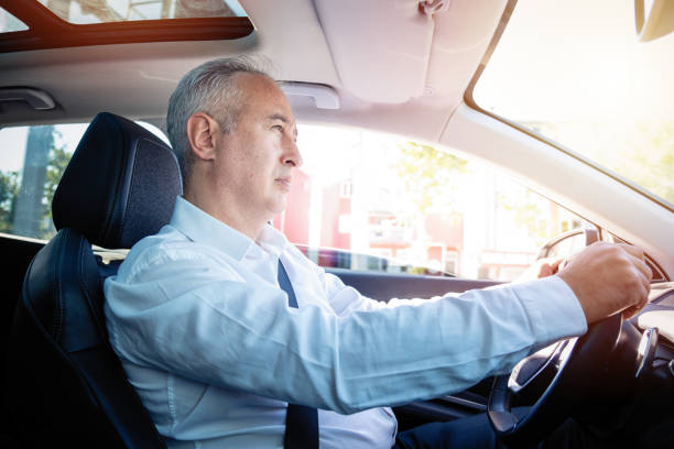 istock White Haired mature businessman driving 1323218453