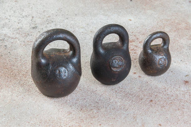 istock Three antique iron weights for scales on concrete background. 1323223187