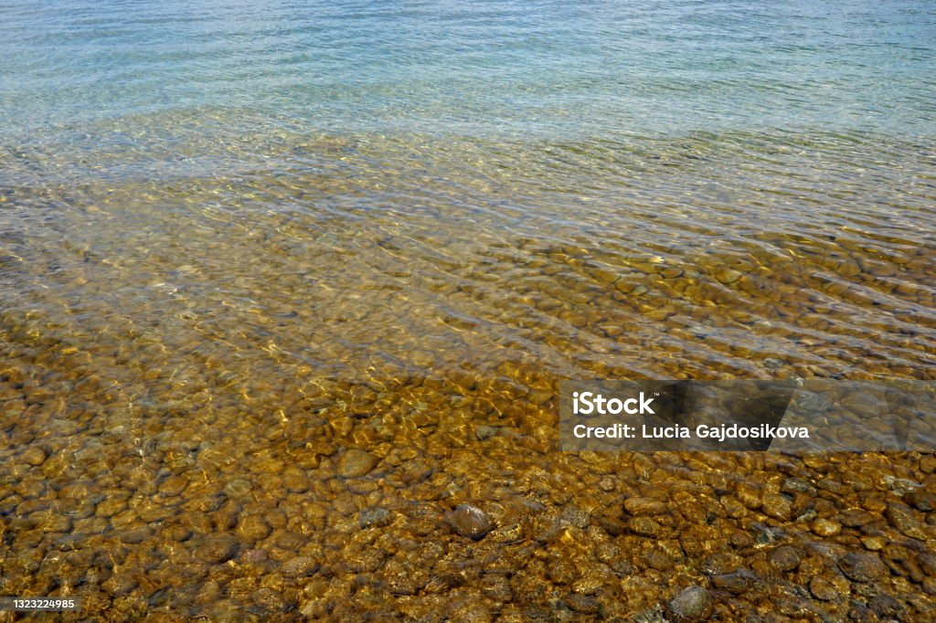 Shallow water of Lake Constance with round stones on the bottom. Shallow water of Lake Constance with round stones on the bottom. Suitable as natural or seasonal background. Bodensee Stock Photo