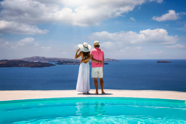una pareja se para junto a la piscina y disfruta de la vista sobre el mediterráneo - sports venue luxury love enjoyment fotografías e imágenes de stock