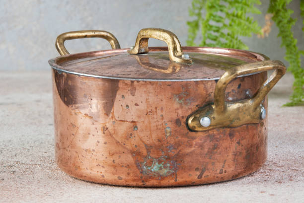 istock Old copper casserole on a concrete background. 1323229804