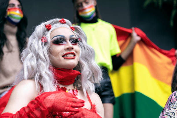 Drag queen smiles as she enjoys her day celebrating gay pride with all her friends. Latin drag queen from Bogota Colombia between 30 and 39 years old, smiles as she enjoys her day celebrating gay pride with all her friends dressed in red dress drag queen stock pictures, royalty-free photos & images