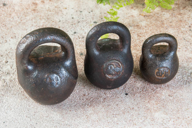 istock Three antique iron weights for scales on concrete background. 1323231843