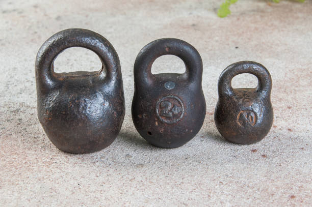 istock Three antique iron weights for scales on concrete background. 1323232450