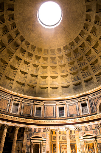 The sun shining through the domed ceiling of the Roman Pantheon.