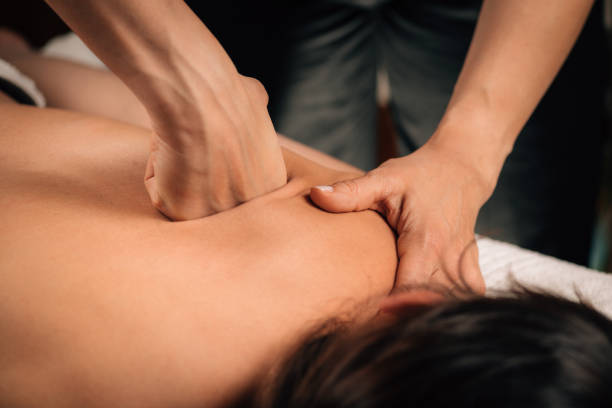 Deep Tissue Massaging. Deep tissue massaging therapy. Therapist hands massaging woman’s shoulder deep stock pictures, royalty-free photos & images