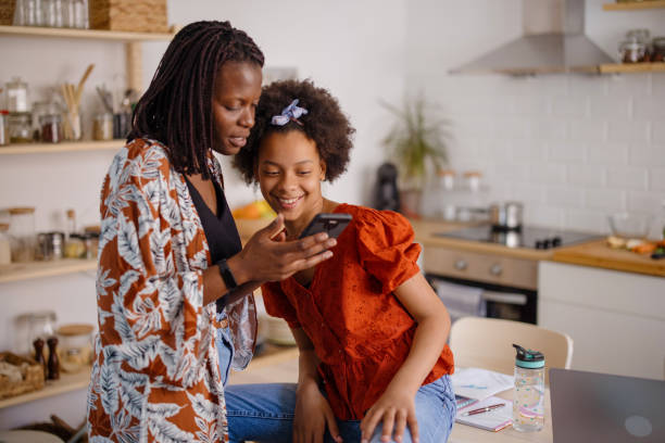 istock Mother and daughter looking at phone together 1323234125