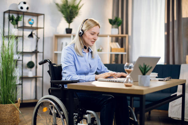 istock Disabled woman in headset having video call on laptop 1323236215
