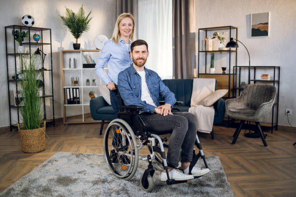 istock Lovely wife helping and supporting disabled husband 1323236425