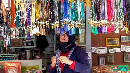 A woman seller places Muslim rosaries to the shop near of mosque on 17 May, 2021 in Izmir, in Turkey