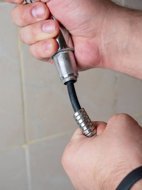 istock Broken chrome shower hose in men's hands. Rift, rubber, selective focus, shower equipment, vertical photo 1323238168
