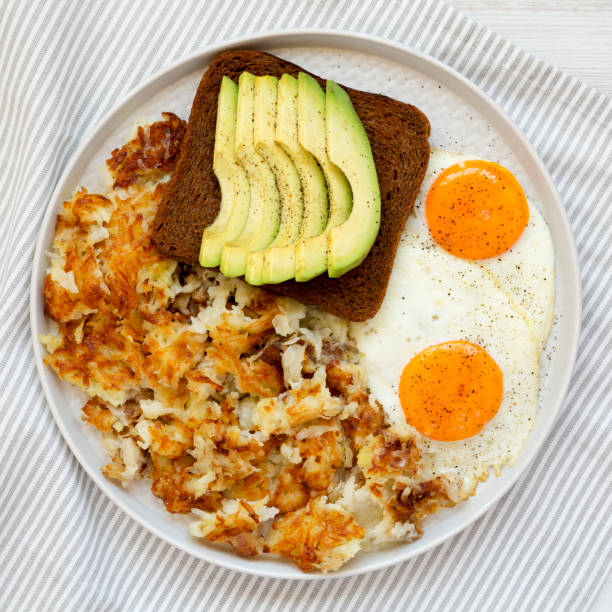 sabrosos hashbrowns fritos caseros y huevos en un plato, vista superior. plana en lay, desde arriba, por encima de la cabeza. - hash brown gold food vegetable fotografías e imágenes de stock