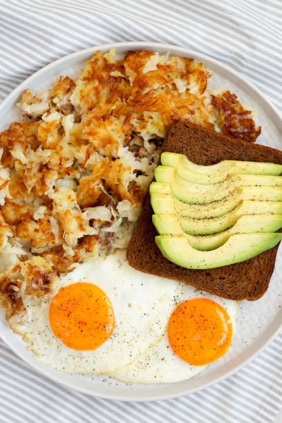 savoureux hashbrowns frits faits maison et oeufs sur une assiette, vue aérienne. pose plate, vue de dessus, d’en haut. - hash brown gold food vegetable photos et images de collection