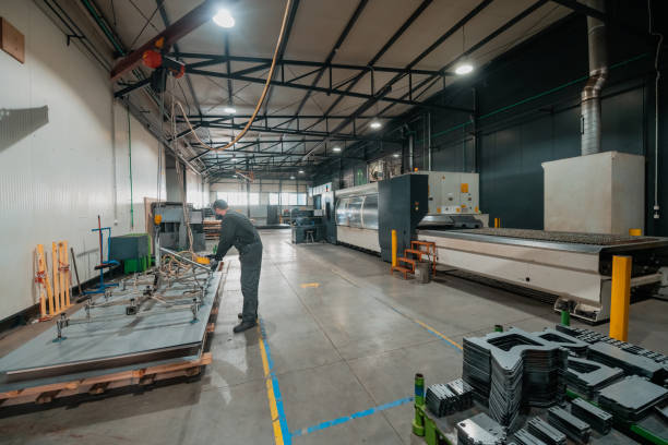 istock a worker working in a modern industry prepares material for processing on a cnc machine, wears a protective mask on his face due to a coronary virus pandemic 1323239311