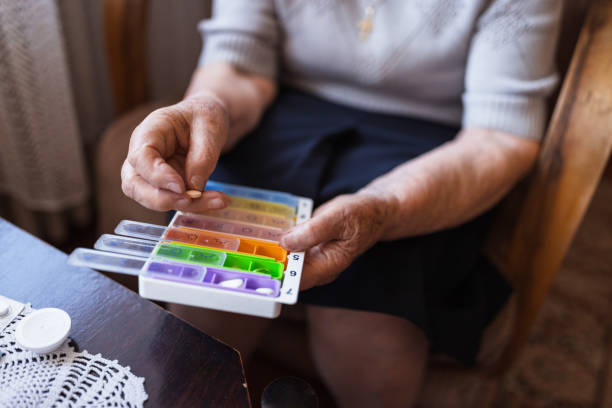istock Grandmother arranging pills into daily storage boxes 1323239329