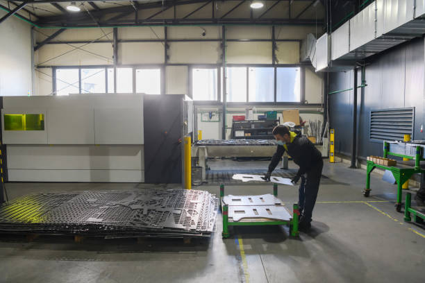 istock a worker working in a modern industry prepares material for processing on a cnc machine, wears a protective mask on his face due to a coronary virus pandemic 1323240129