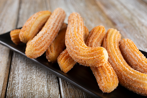 A view of a plate of churro pieces.