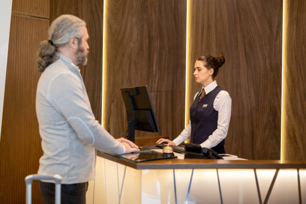 istock Senior male waiting for receptionist entering his name in computer 1323260459
