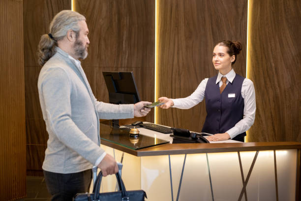 istock Young receptionist taking documents of mature man 1323260469