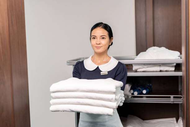 istock Pretty room service staff holding clean sheets 1323260510