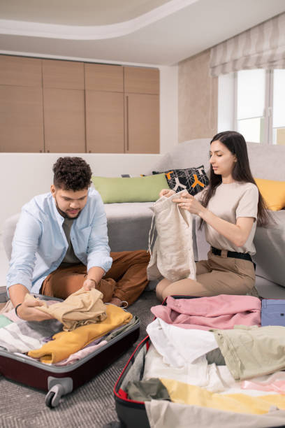 istock Young husband and wife packing suitcases 1323260526