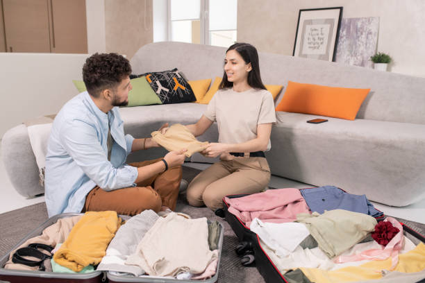 istock Happy young couple packing suitcases before journey 1323260529