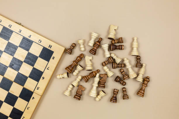 istock Chess board and chess figures on beige background. Popular logic game for logical thinking. 1323262991