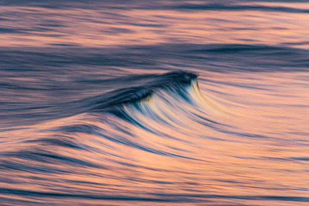 istock Artistic photograph of pink cresting ocean wave 1323263727