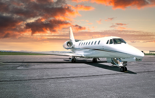 A private white jet airplane sitting on the runway.