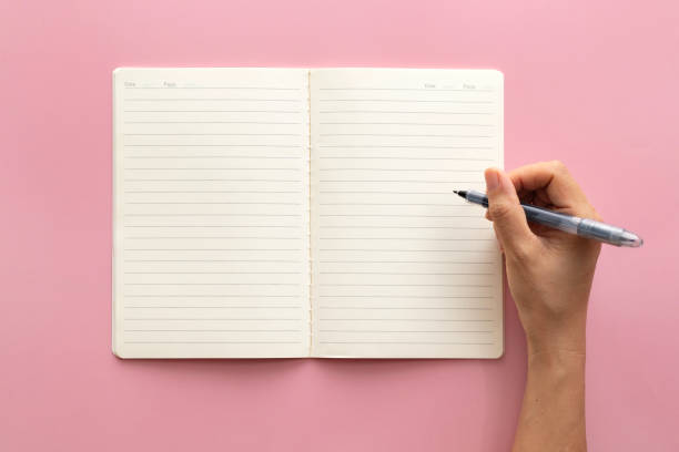 Note Pad and Pen on Pink background stock photo